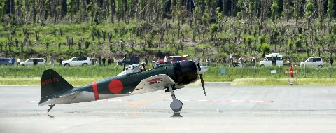 離陸を待つ零戦復元機。後方は一目見ようと集まった人たち＝３１日午後２時５０分すぎ、熊本県益城町